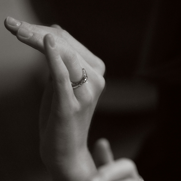 obrączka z białego i żółtego złota o nieregularnym, falistym kształcie z brylantami białymi i czarnymi projektu Marty Szafraniec, projektantki z Katowic