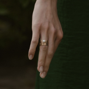 dłoń o długich palcach z pierścionkami z perłą, biżuteria wyjątkowa i idealna na preznet na ważne okazje.